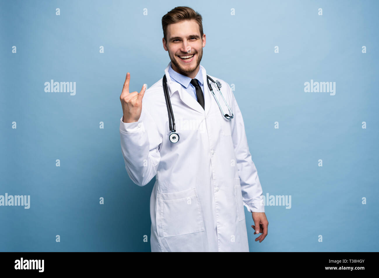 Chirurg Arzt Mann stolz und selbstbewusst in Liebe sich Konzept zufrieden isoliert auf Hellblau. Stockfoto