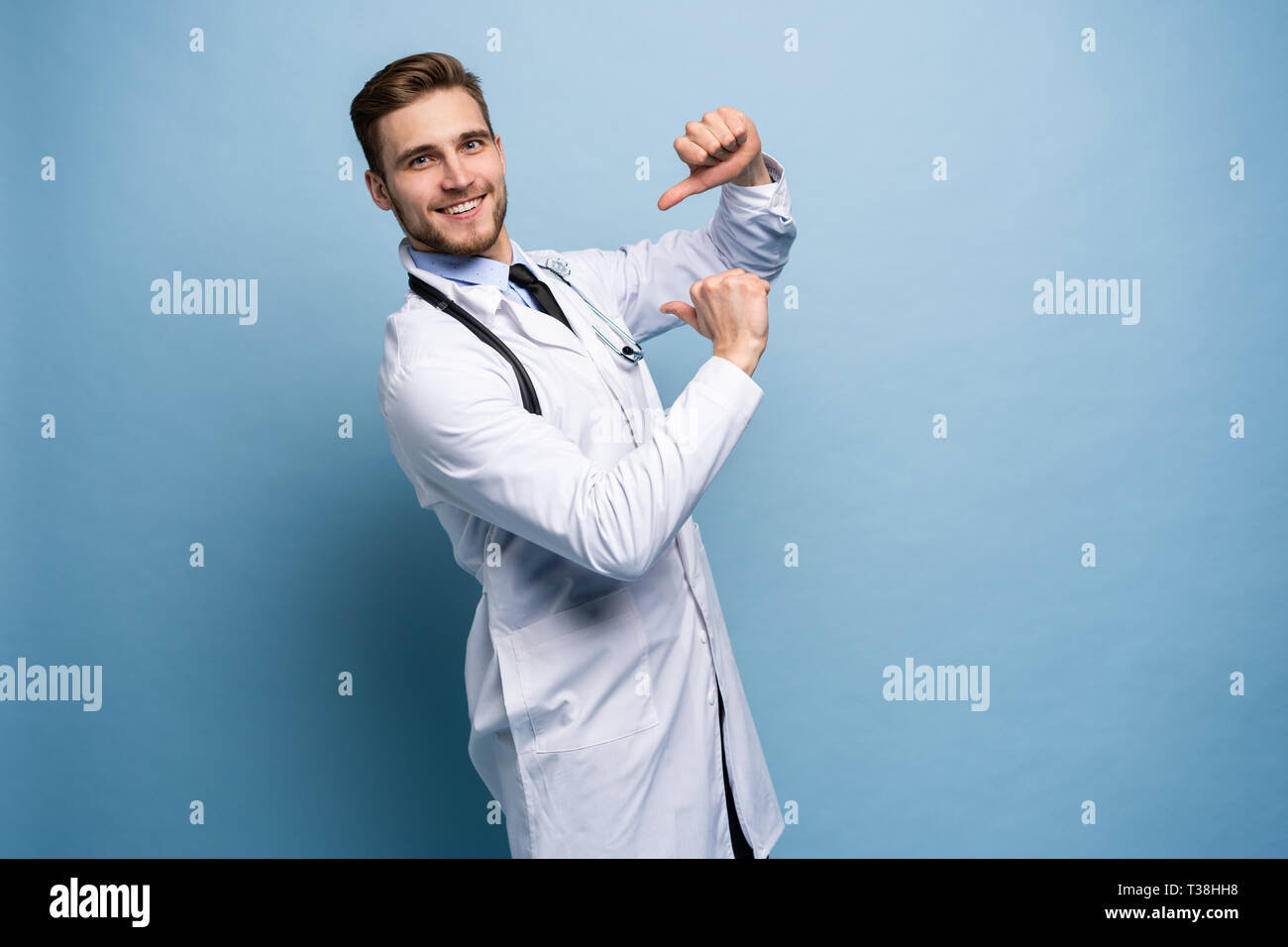 Chirurg Arzt Mann stolz und selbstbewusst in Liebe sich Konzept zufrieden isoliert auf Hellblau. Stockfoto