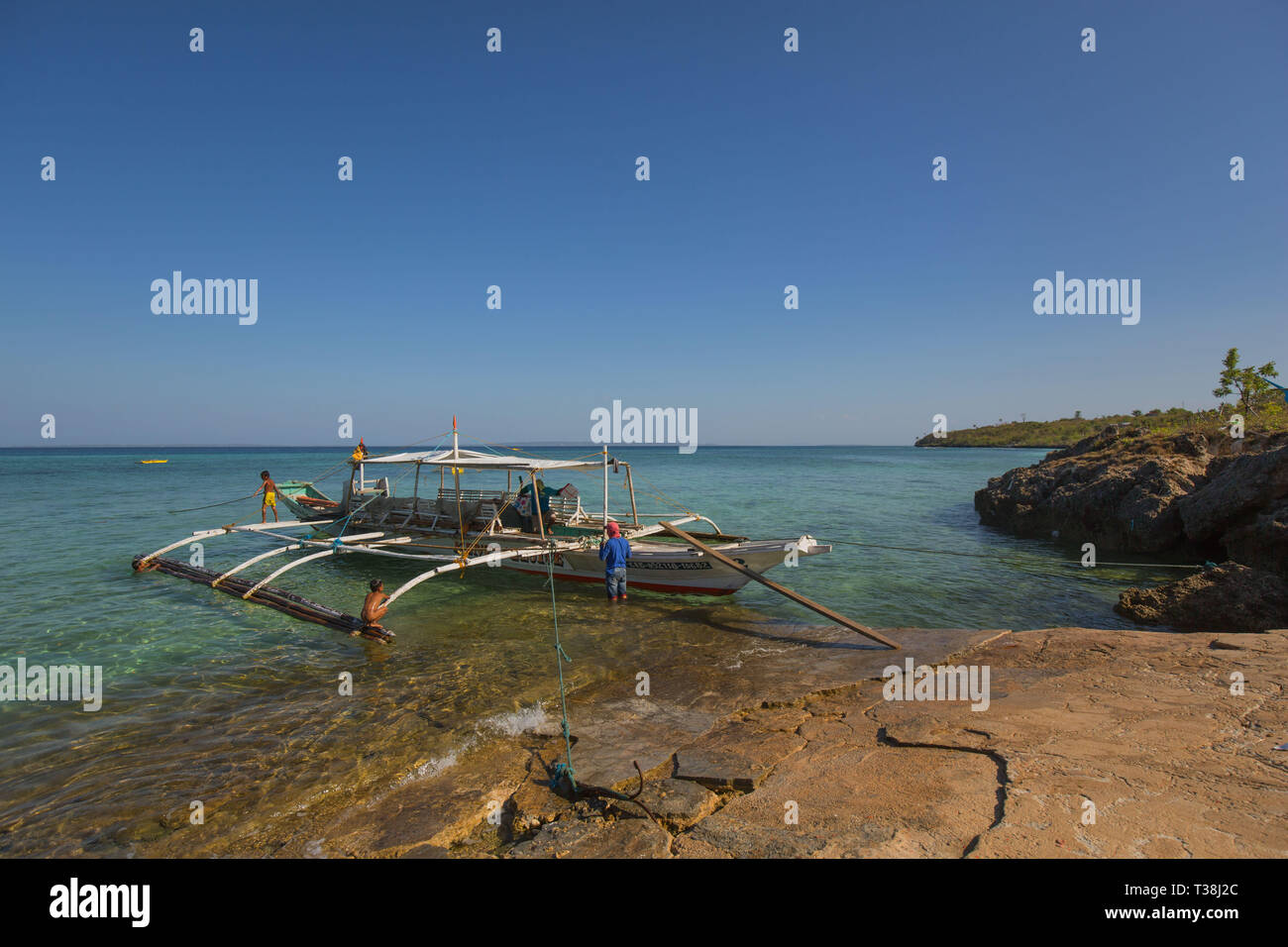 Ländliche Provinz Island Pier mit outrigger Fähre an der Küste Ankern, in einem ruhigen Nachmittag Sommer sonnigen Tag Hintergrund Foto Stockfoto