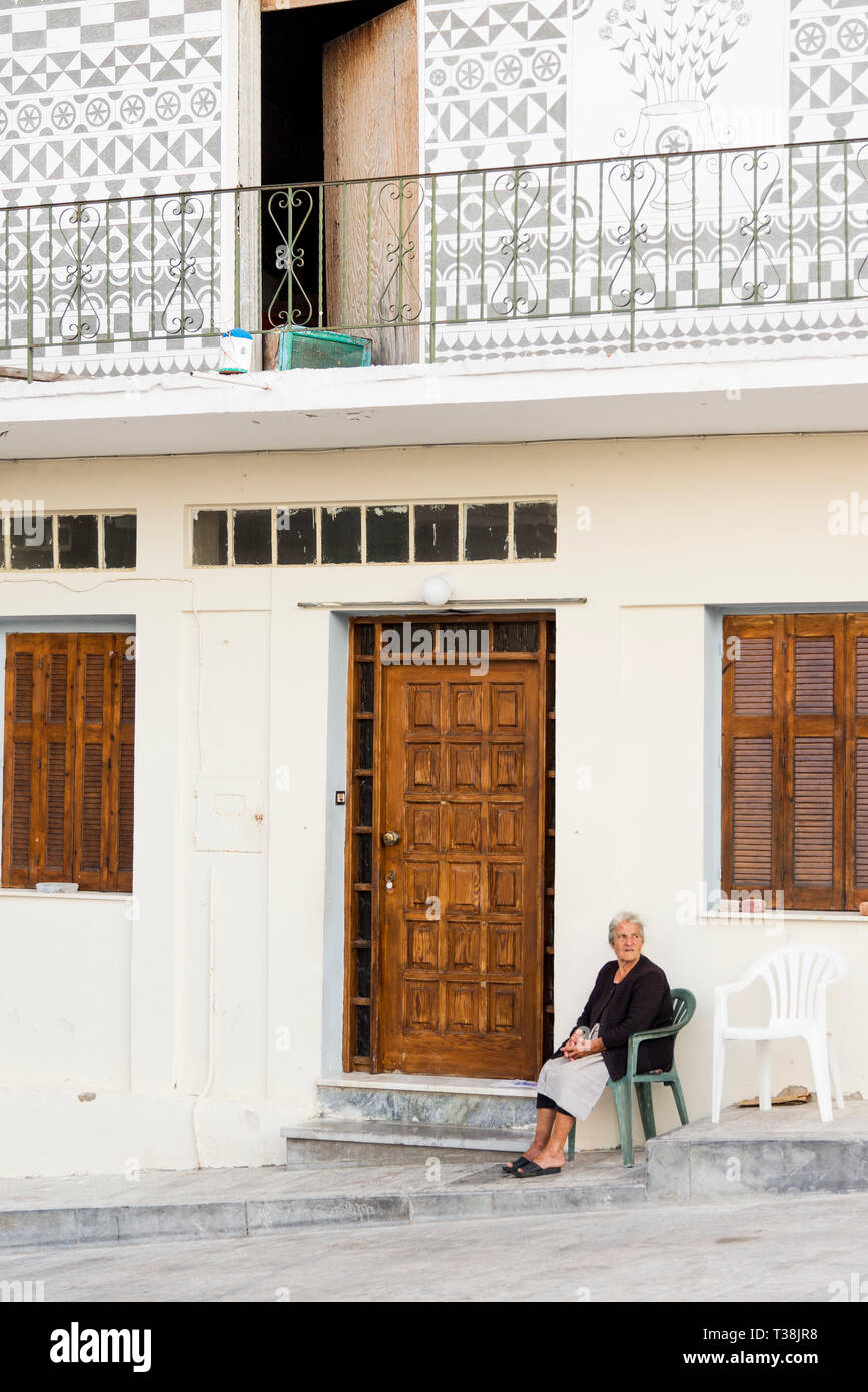 Chios, Griechenland - 18 August, 2018: Street View von pyrgi Insel Chios Griechenland mit einer Frau, die auf einem Stuhl sitzen. Stockfoto