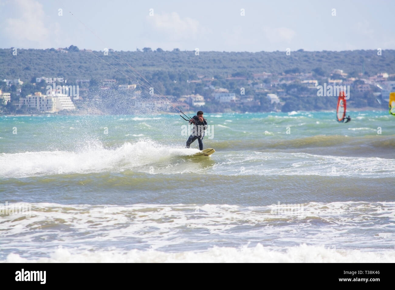 CAN PASTILLA, MALLORCA, SPANIEN - April 6, 2019: Nahaufnahme von männlichen jungen Surfer reiten grüne Wellen, die sich im Stil an einem windigen, sonnigen Tag am 6. April 2019 in C Stockfoto