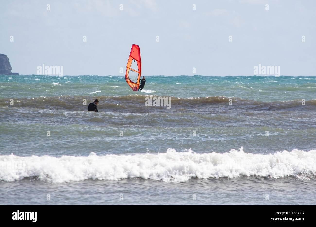 CAN PASTILLA, MALLORCA, SPANIEN - 6. APRIL 2019: Windsurfer mit Red Sail spielt in die grünen Wellen an einem windigen, sonnigen Tag am 6. April 2019 in kann Vergangenheit Stockfoto