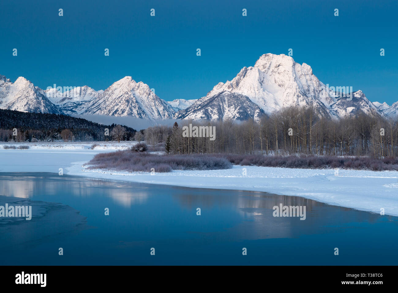 Eisige Wasser in Oxbow Bend die Schnee-bedeckten Mount Moran und Teton Mountains an einem kalten Wintermorgen. Der Grand Teton National Park, Wyoming Stockfoto