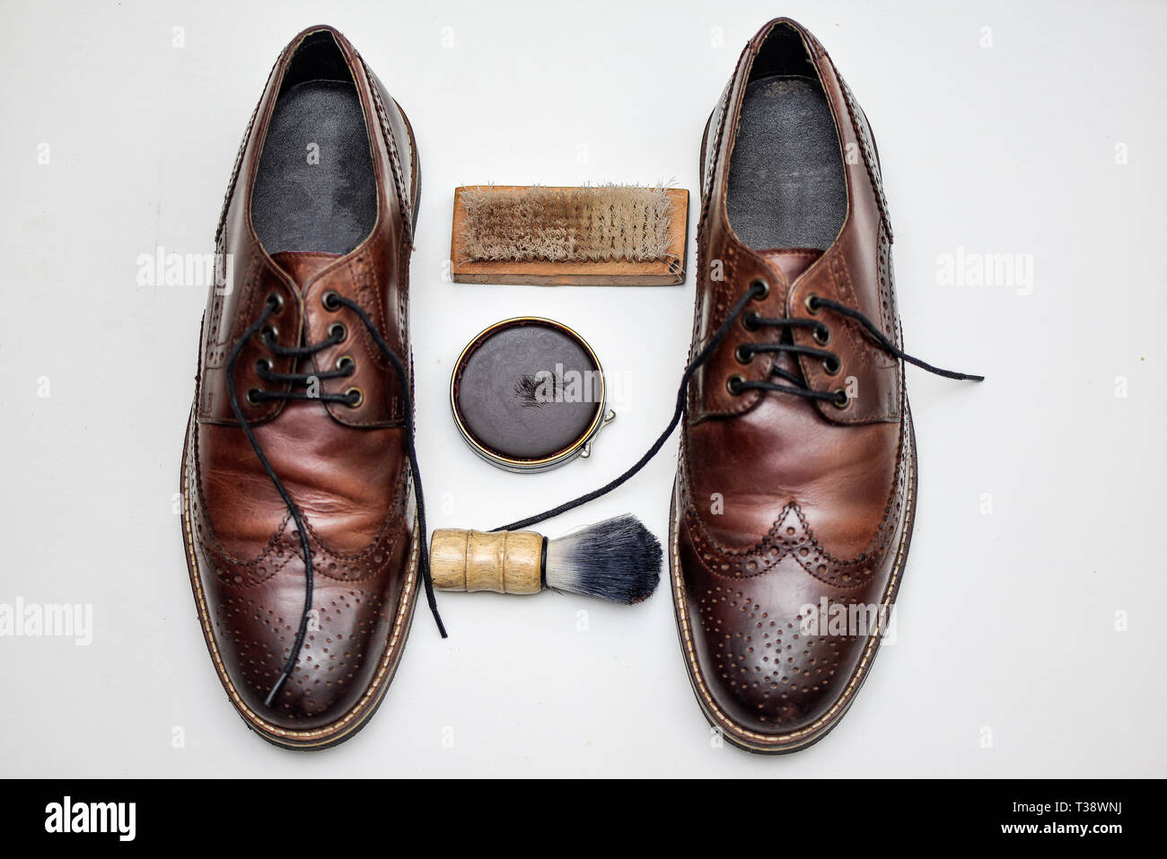 Ein ziemlich verwendet Paar braune Schuhe mit Schuhcreme, Bürste, Schuhspanner, Fuß Füller und anderes Zubehör Stockfoto
