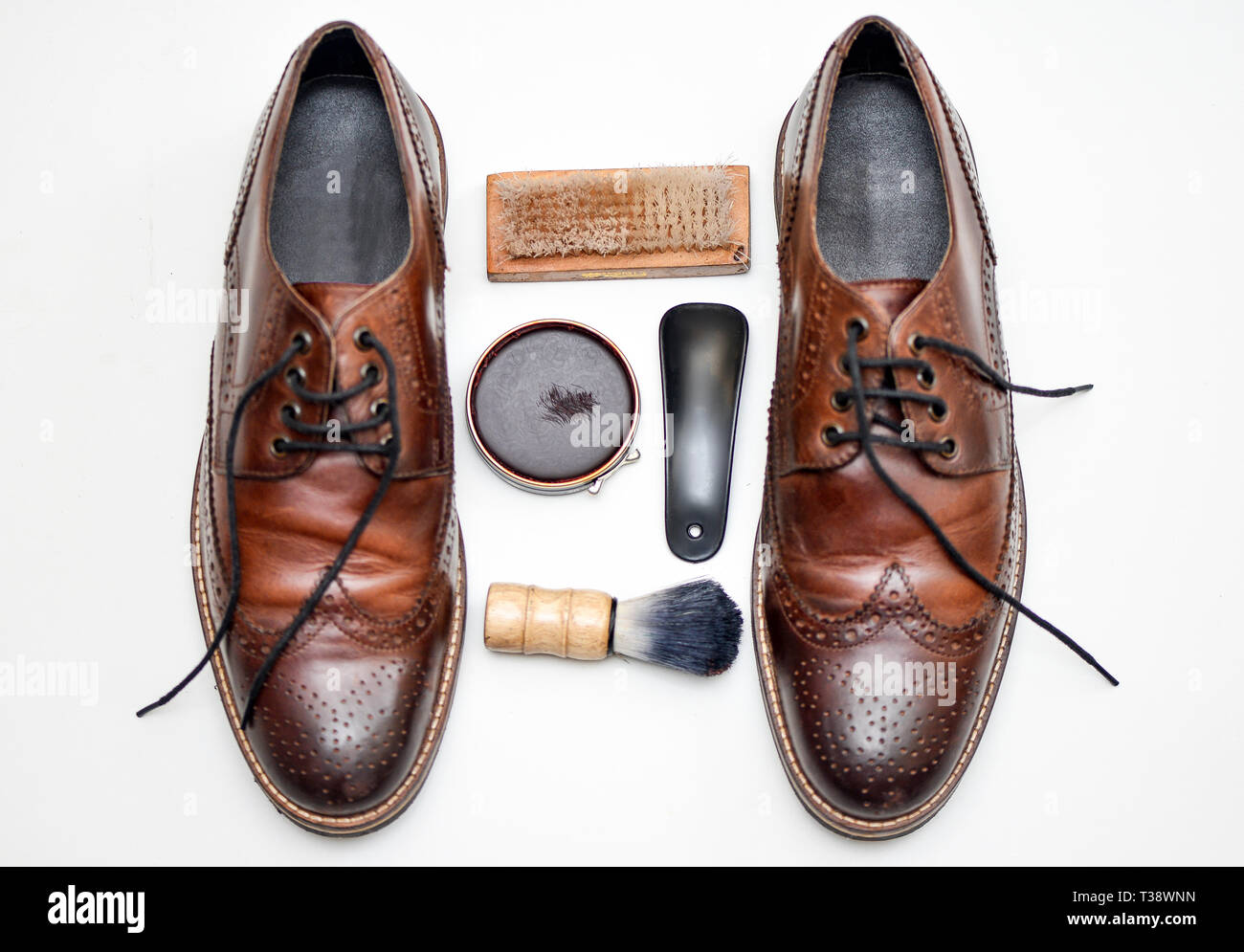 Ein ziemlich verwendet Paar braune Schuhe mit Schuhcreme, Bürste, Schuhspanner, Fuß Füller und anderes Zubehör Stockfoto