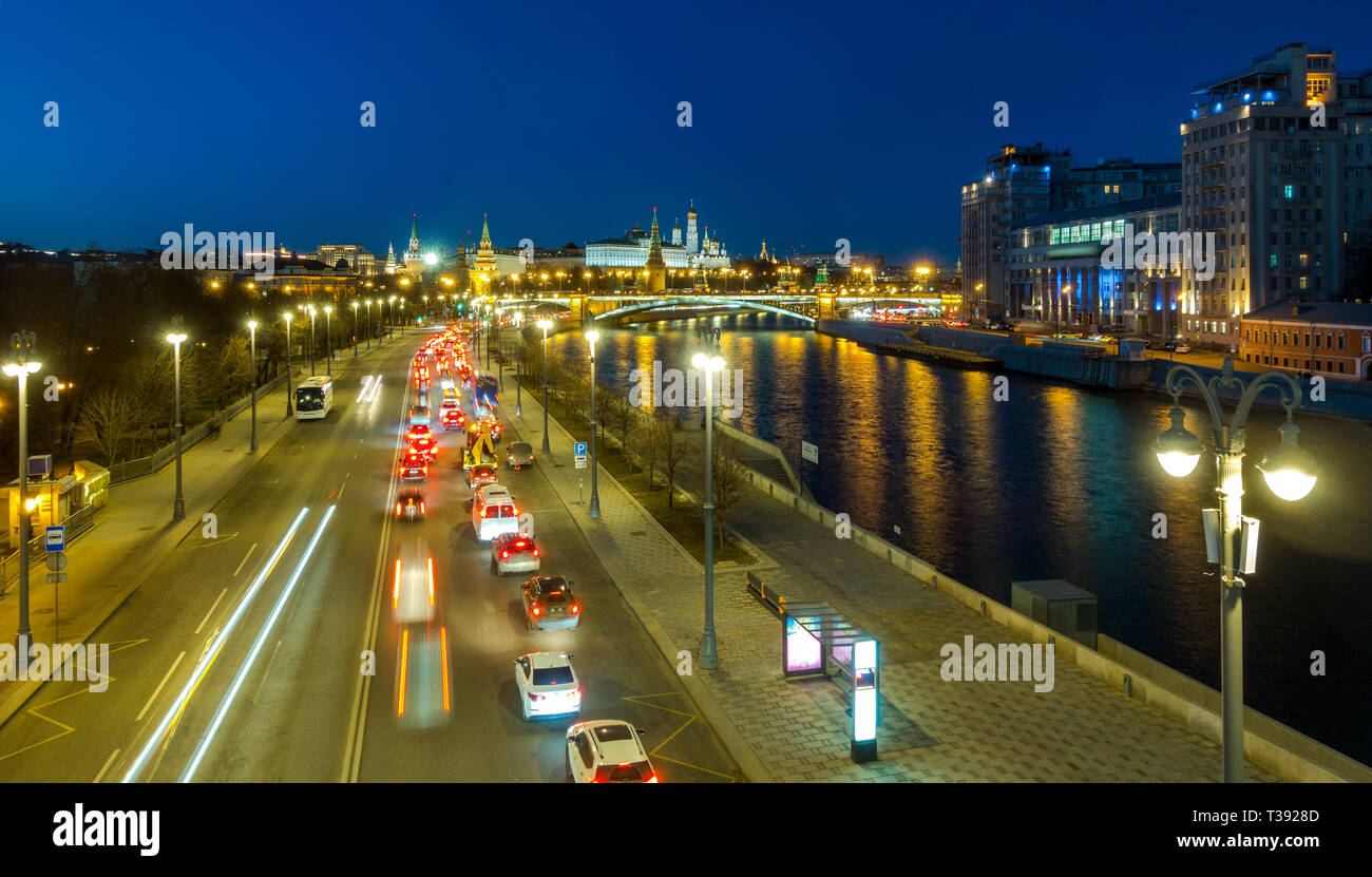 Auto Verkehr auf Prechistenskaya Böschung. Abendlicher Blick von Moskau Fluss, Bolshoy Kamenny Brücke und Kreml. Stockfoto