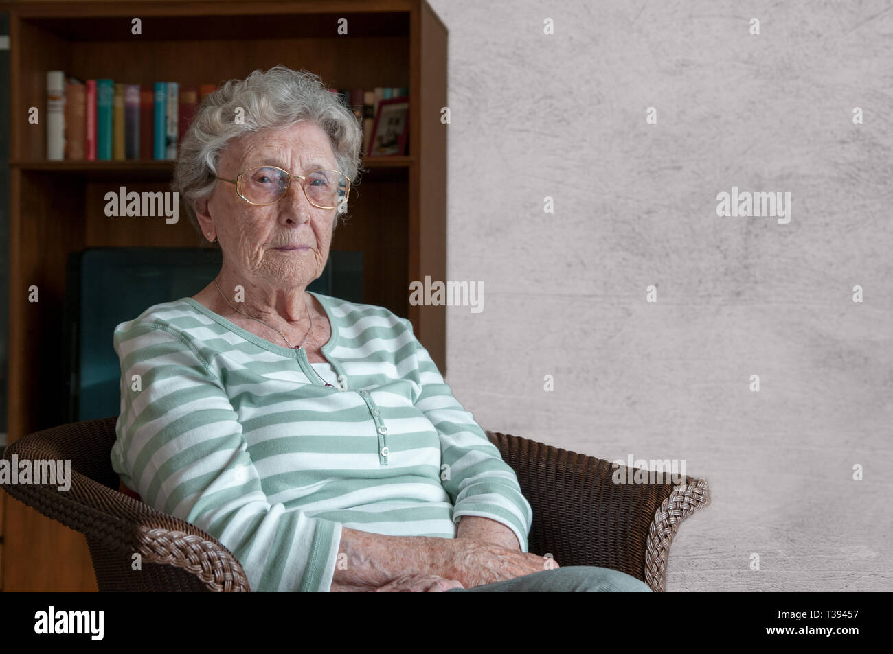 Einsame ältere Frau im Sessel sitzen Stockfoto