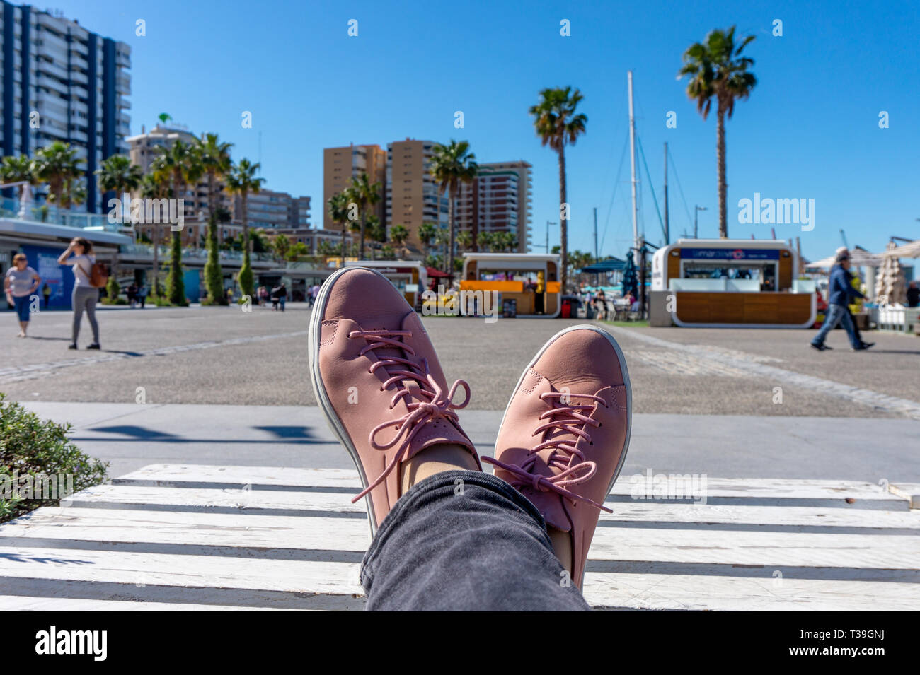 Frau im Sport Schuh sneaker Chillen am Hafen Malaga an einem sonnigen Tag Stockfoto