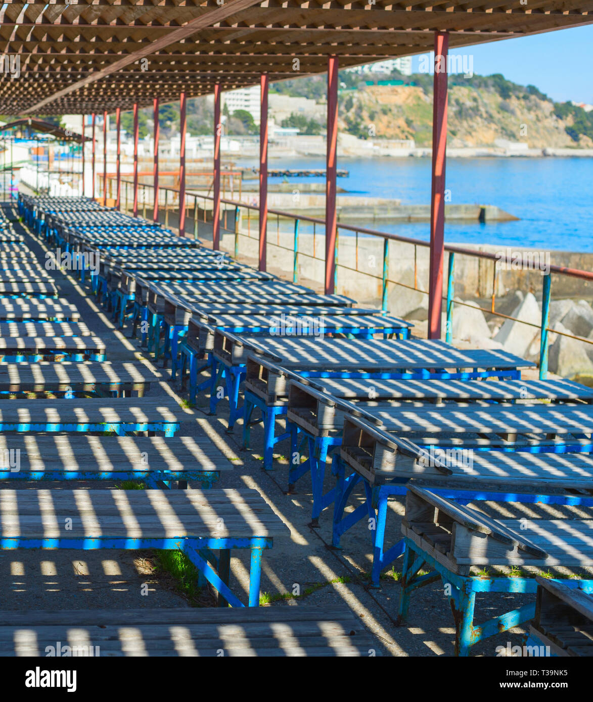 Alte hölzerne Liegestühle am Strand von der Krim. Die Ukraine Stockfoto