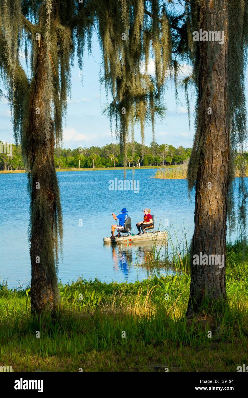 Mann und Frau angeln von einem kleinen Boot zusammen für Bass Fisch auf Hardee Lake County Park Florida Campground Stockfoto