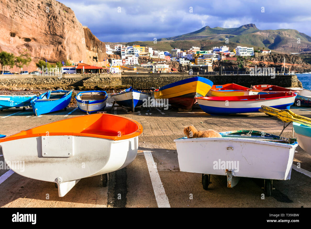 Traditionelle bunte Boote, das Meer und die Berge in Puerto de Sardina Dorf, Gran Canaria, Spanien. Stockfoto