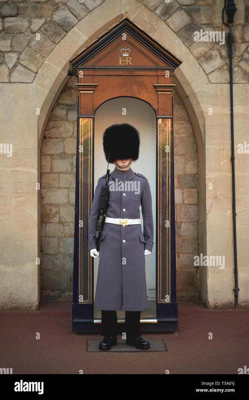 Windsor, Großbritannien - Dezember, 2018. Ein sentry Grenadier guard in seine ikonische einheitliche außerhalb Windsor Castle Gate. Stockfoto