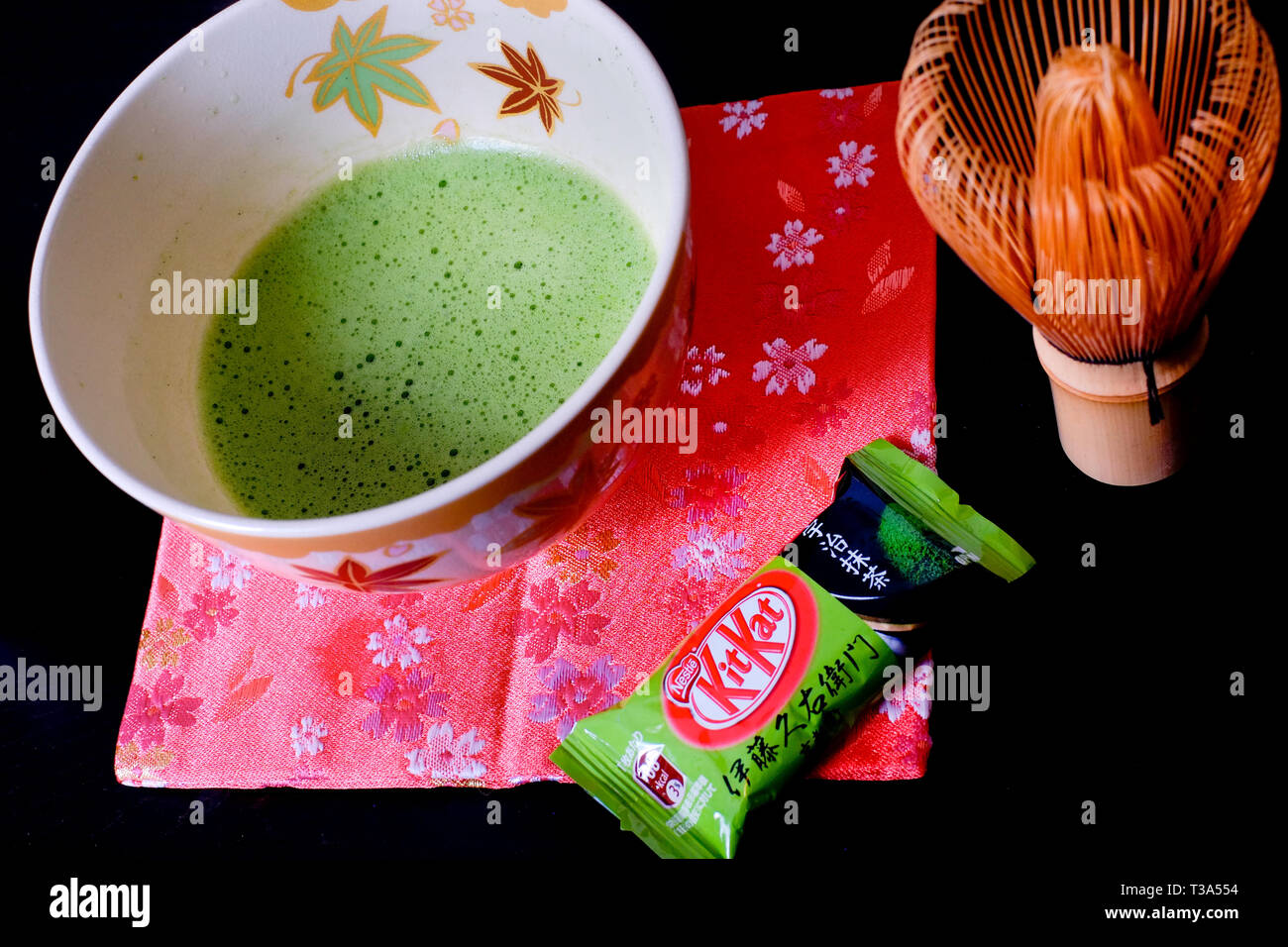 Eine japanische Uji Matcha Grüntee Kit Kat sitzt neben einer Schüssel gebraut dünnen Kaffee. Stockfoto