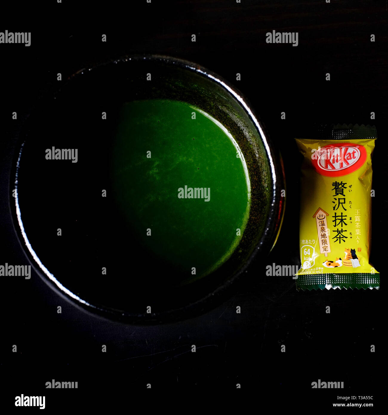 Ein japanisches Luxus Matcha Grüntee Kit Kat neben einer Schüssel mit dicken Matcha Tee. Stockfoto