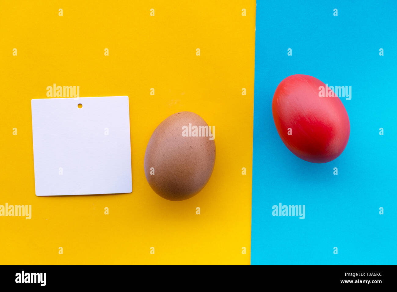 Rot lackiert und raw Osterei Auf buntes Papier Gelb und Blau und Weiß memo Papier Hinweis Hintergrund Stockfoto