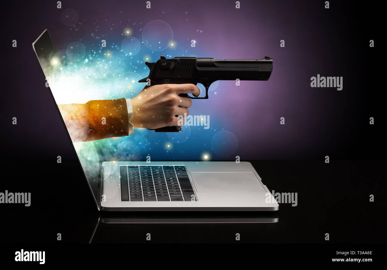 Hand mit Gewehr aus einem Laptop mit funkelnden Effekten Stockfoto