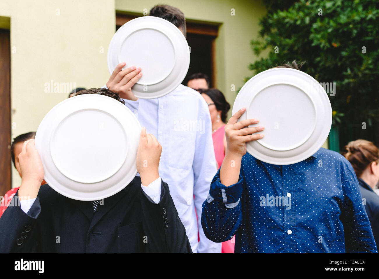 Portrait von drei Kinder ihre Gesichter verbergen mit leeren Teller, Konzept der Privatsphäre und Sicherheit. Stockfoto