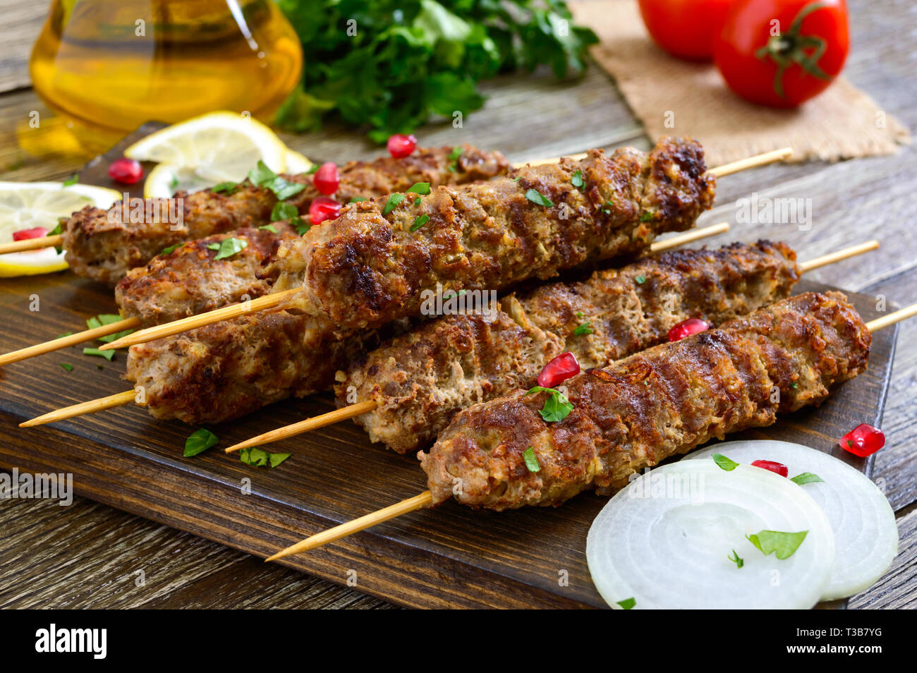 Köstliche lula Kebab auf einem Holztisch. Gehacktes Fleisch auf Holzspieße, gegrillt. Östliche Küche. Stockfoto