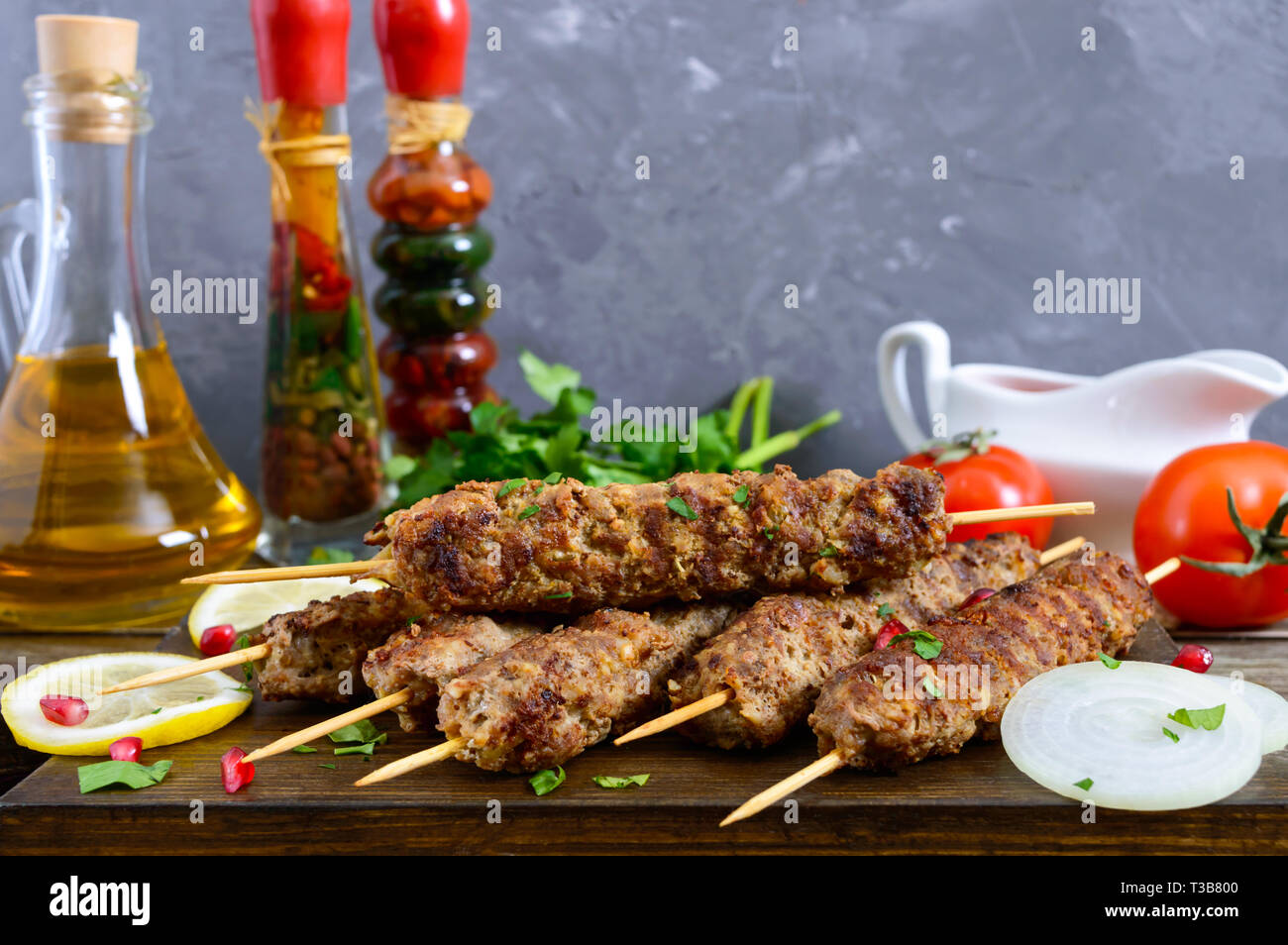 Köstliche lula Kebab auf einem Holztisch. Gehacktes Fleisch auf Holzspieße, gegrillt. Östliche Küche. Stockfoto