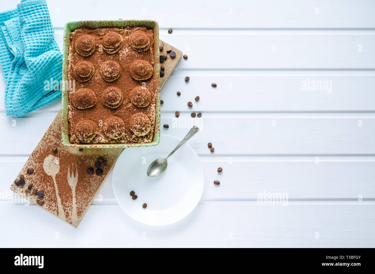 Fach mit Tiramisu Dessert mit Schokolade auf weißem Holz- Hintergrund. Ansicht von oben mit Speicherplatz zu kopieren. Stockfoto
