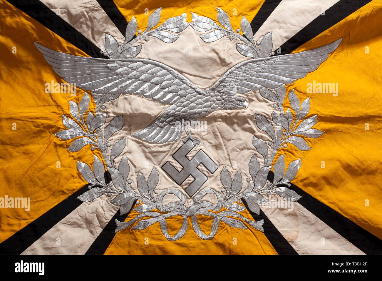 Ein Banner für Luftwaffe fliegende Einheiten oder Airborne Einheiten ganz aus Seide mit silber Franse auf drei Seiten. Gelb mit einer weißen Scheibe auf beiden Seiten von einem Lorbeerkranz umgeben. Ein Silber-bestickt Luftwaffe Adler mit längeren Flügeln innerhalb der Kranz auf der einen Seite und ein eisernes Kreuz innerhalb der it auf der anderen. Vier weiße diagonalen Strahlen mit schwarzen Kanten Ausweitung in Richtung der Ecken, die Hakenkreuze tragen schwarze Seide mit Silber grenzt. Helle Farben. Markierungen der Nägel auf dem Ärmel. Verschmutzt. Spuren von Farbe oder Schimmel am unteren Rand der Vorderseite. Abmessungen Ca. 1, Editorial-Use - Nur Stockfoto