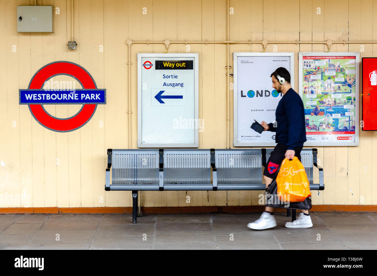 Ein Mann Spaziergänge entlang der Plattform, die Sie an der Ausfahrt Westbourne Park London Underground Station. Stockfoto