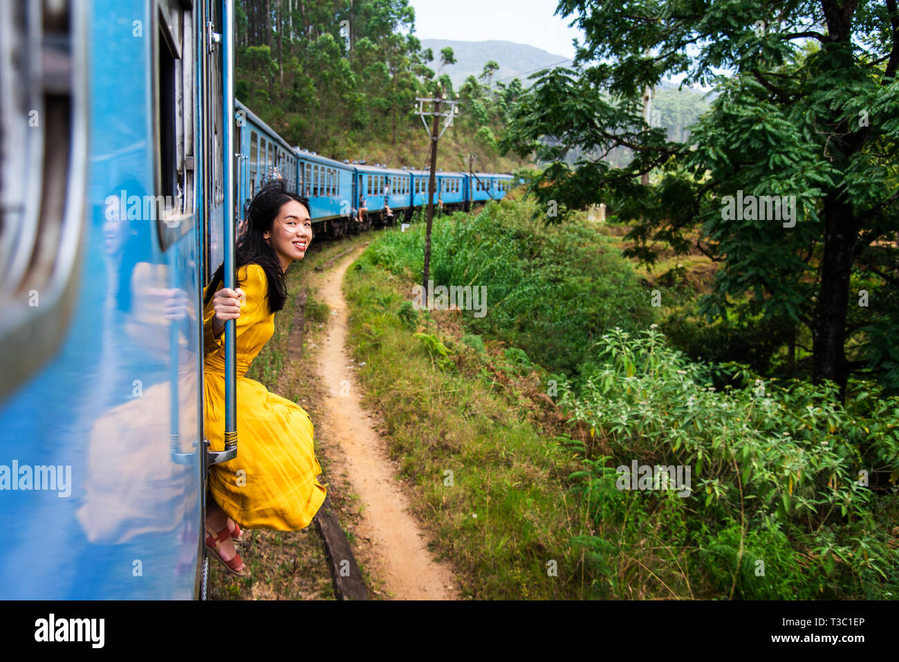Die Frau, die durch die blaue Tür Sri Lanka sitzen Stockfoto