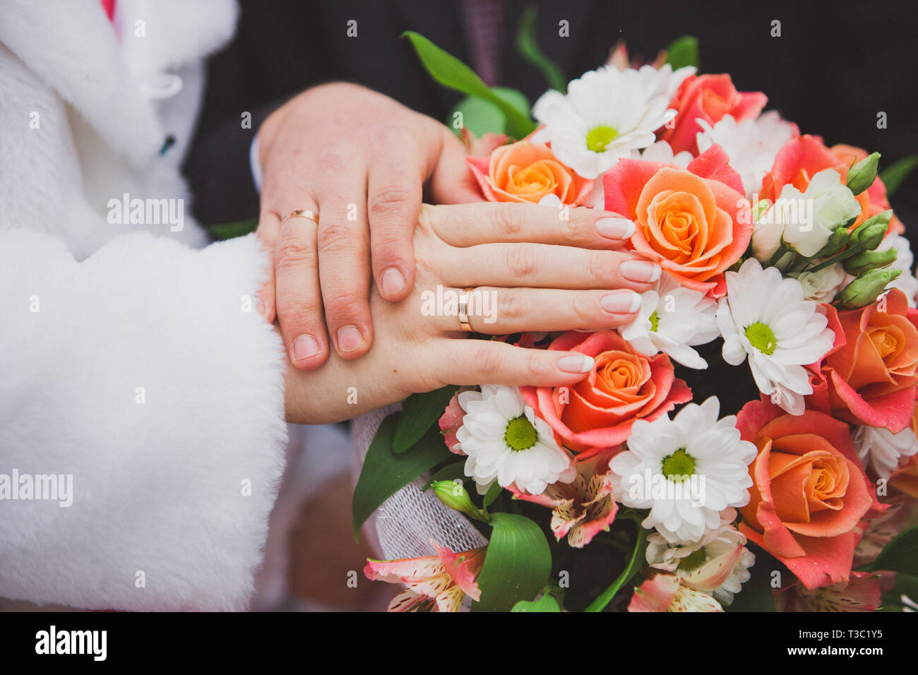 Wedding Bouquet - die Hände des Bräutigams und der Braut mit eleganten Maniküre und goldene Ringe Stockfoto