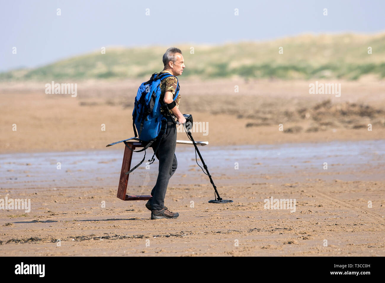 Ein Metall detectorist mit einem Detektor und Raster marker Jagt für verborgenen Schatz auf dem Sand von Southport Strand in Merseyside. Stockfoto