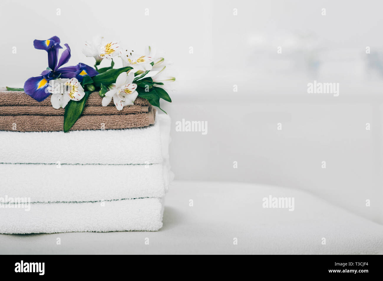 Ruhige Szene mit Handtüchern und Blumen im Spa. Weiße Handtücher, Aromatherapie und Wellness Behandlung Stockfoto