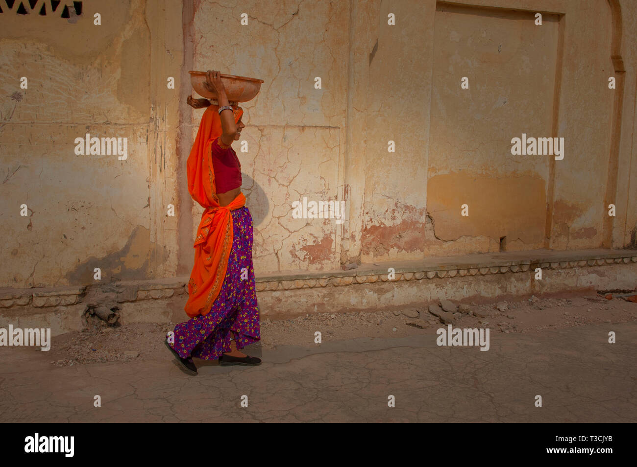 Indische Frau eine schwere Last auf den Kopf Stockfoto