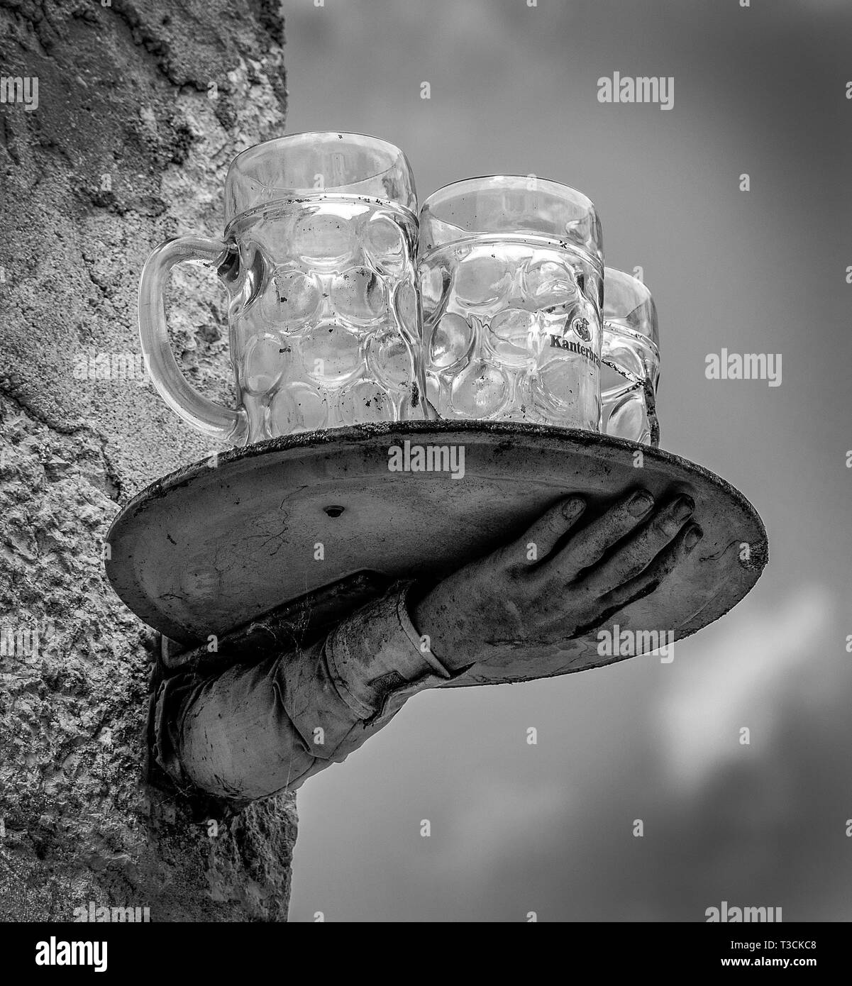 Ein Bild von einem Hand- und Tablett mit Gläsern, als ob, der aus der Wand in ein gespenstisches surreale Mode Stockfoto