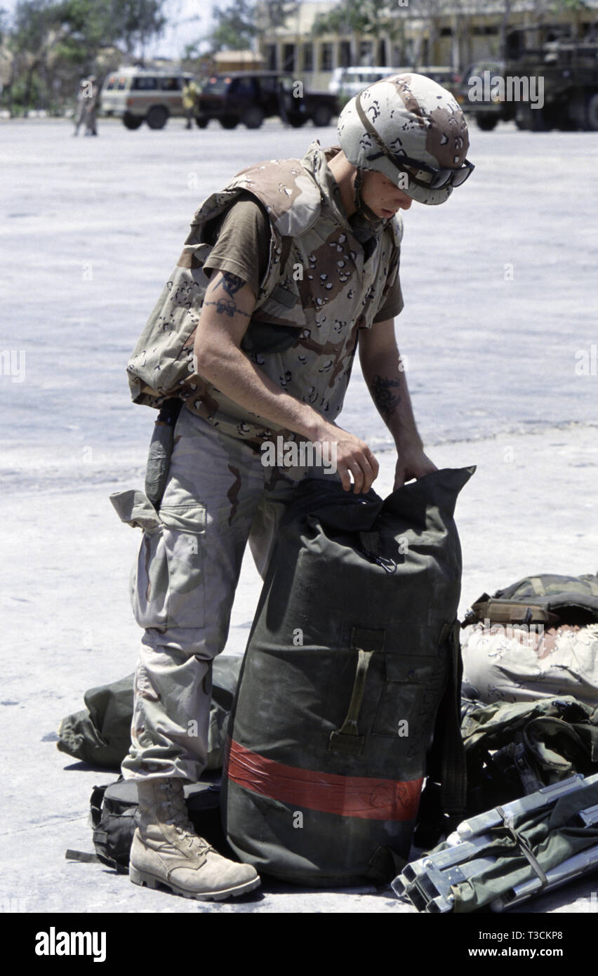 30. Oktober der US-Army Soldaten 1993, Private Robinson des 24 Infanterie Division, prüft seine kit Tasche mit anderen Stücke des Satzes um seine Füße zerstreut, nachdem sie nur per Schiff in den Hafen von Mogadischu, Somalia angekommen. Stockfoto