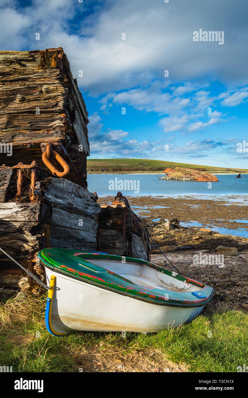 Holz- Stapel und Strände Yacht durch die Churchill Barrier und blockship zwischen Burray und Blick Holm, Orkney Inseln. Stockfoto