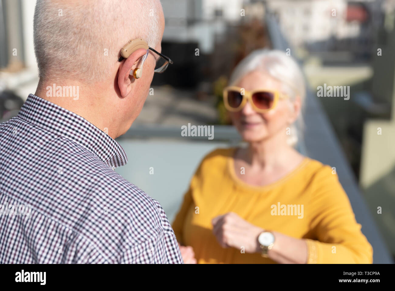 Ältere Menschen, Gehörlose Menschen verwendet ein Hörgerät. Zwei Menschen Gespräch Stockfoto