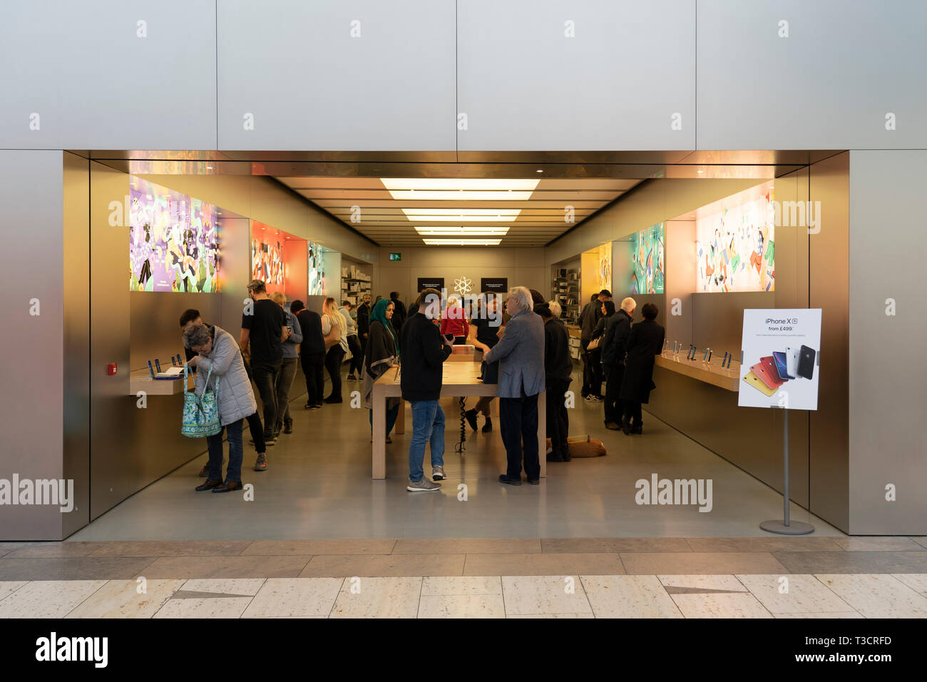Kunden surfen Produkte in einem Apple Store in der Touchwood Einkaufszentrum, Solihull, Großbritannien Stockfoto