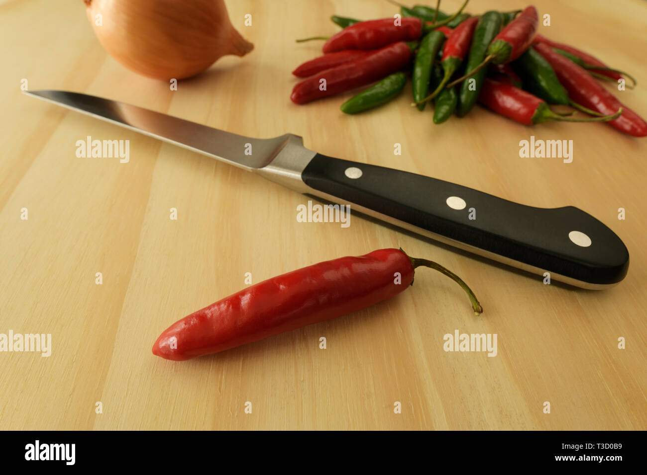 Nahaufnahme, Detail, Stillleben von red chili und Messer mit Lebensmittelzutaten, kochen Vorbereitung auf Holz- Oberfläche, Objekte, Spice Stockfoto
