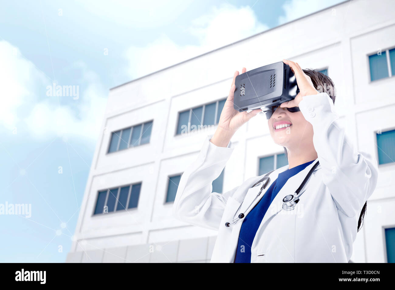 Asiatische Frau Arzt im weißen Kittel und Stethoskop können Sie über Virtuelle Realität Gerät mit Krankenhaus Hintergrund. Augmented Reality Technologie Stockfoto