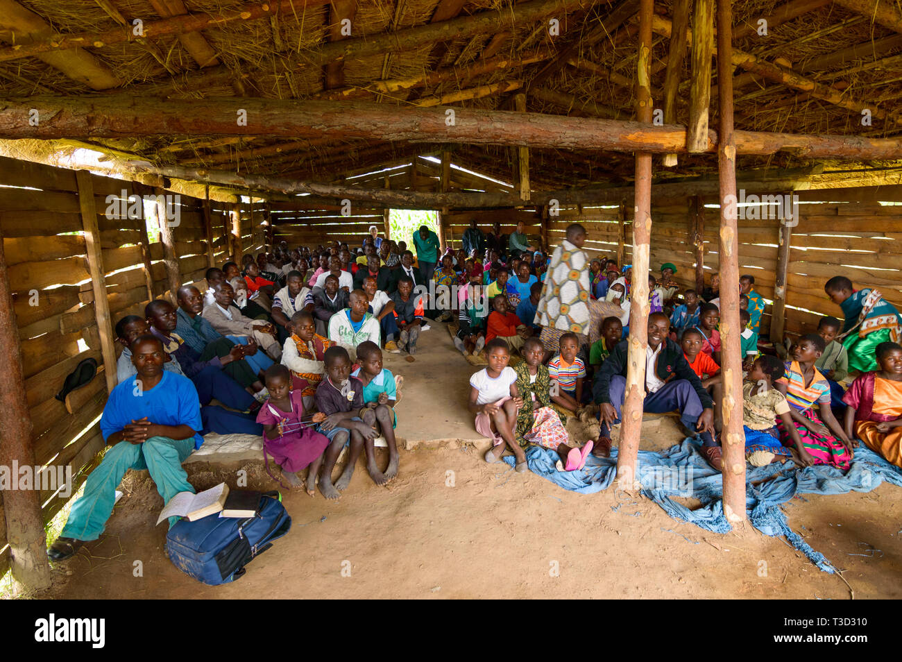 Viele Menschen auf dem Boden eines hölzernen Gebäude der Kirche in einem Dorf in Malawi eingesetzt Stockfoto