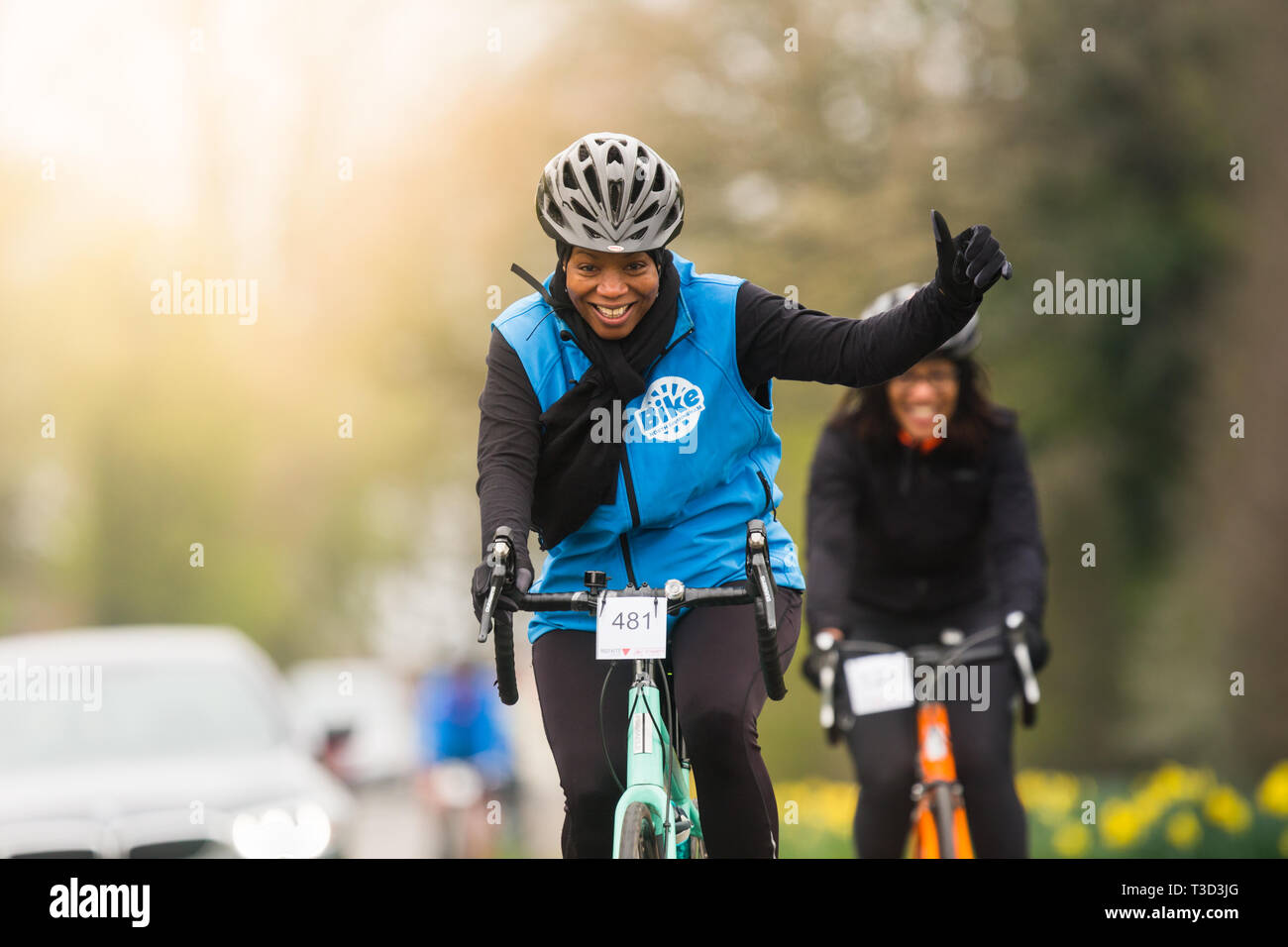 Schwarze britische Frau Radfahren und geben Daumen Anmelden UK Stockfoto
