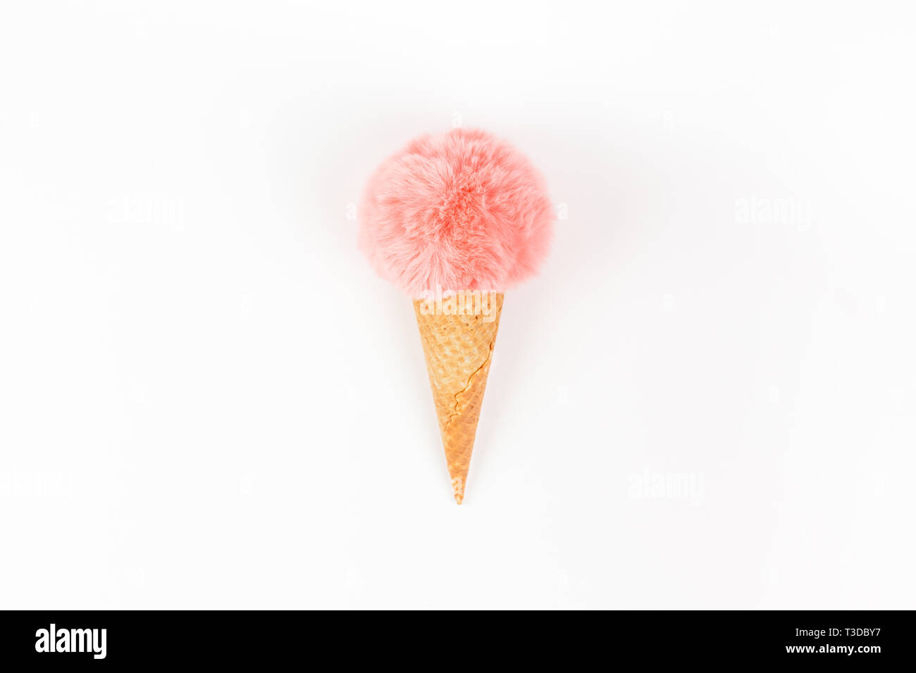 Kreative, oben flach der Koralle Farbe flauschige Fell Kugel Eis Waffel Kegel mit Kopie Raum auf weißem Hintergrund im minimalistischen Stil. Konzept femin Stockfoto