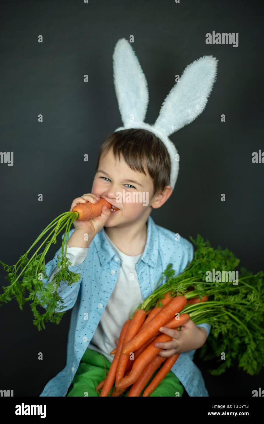 Kleine junge isst Karotte. Stockfoto