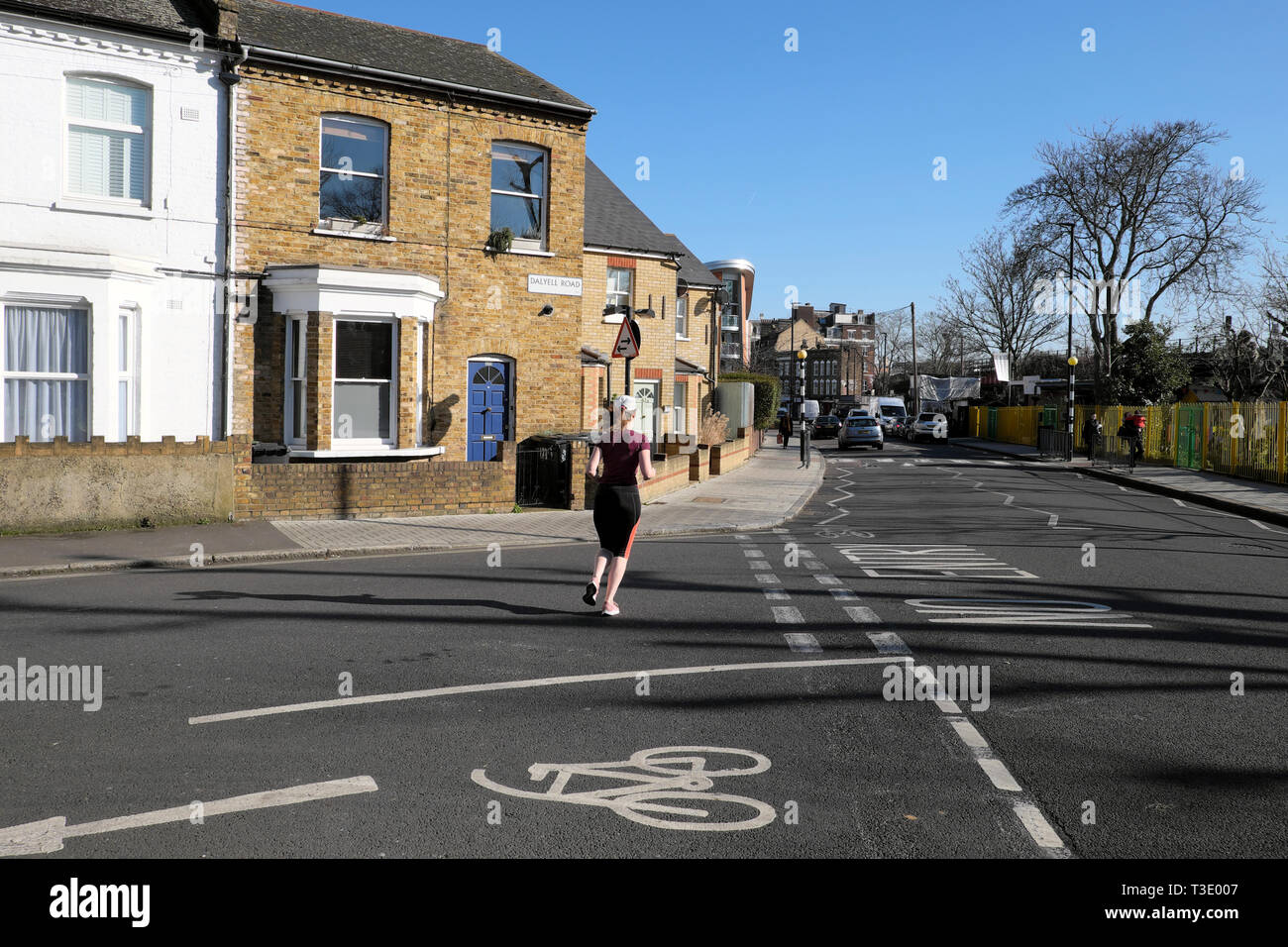 Rückansicht einer jungen Frau mit Lycra entlang Pulross Rd an der Ecke der Straße Dalyell Häuser in Brixton South London England UK KATHY DEWITT Stockfoto