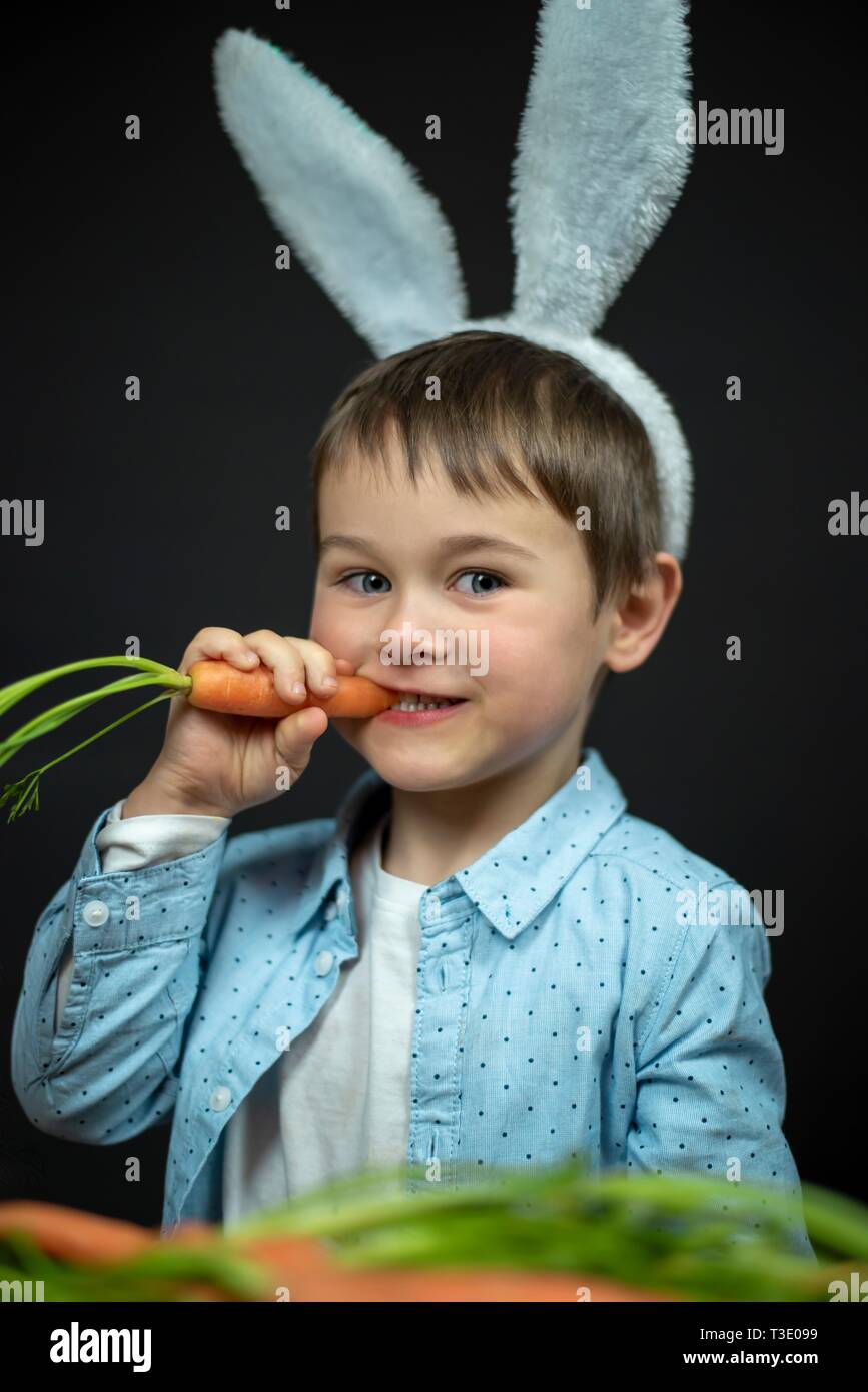 Kleine junge isst Karotte. Stockfoto