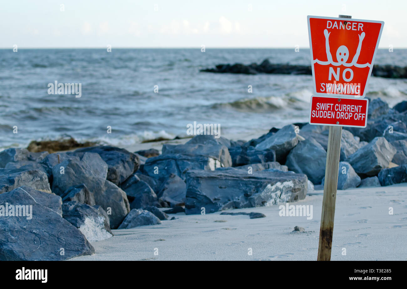 Ein "Schwimmen" Schild warnt Schwimmer von Swift Ströme und die Gefahr der rip-Ströme und ein starker Sog rund um Stegen in Dauphin Island, Alabama. Stockfoto