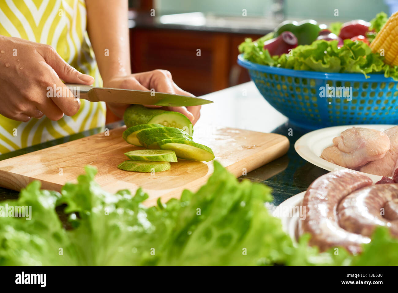 Schneiden Gurke für Salat Stockfoto