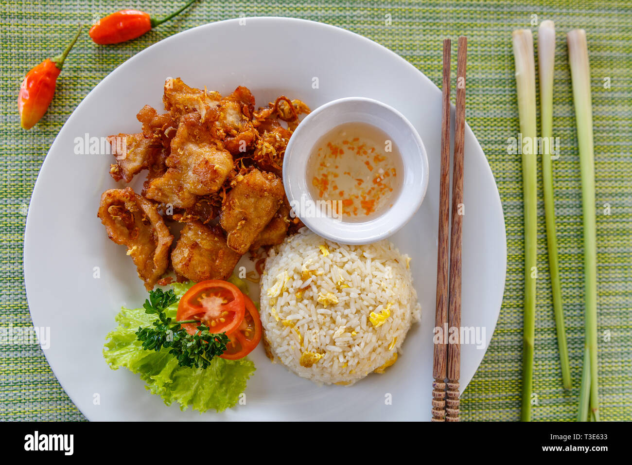 Vietnamesischen traditionellen gebratenes Schweinefleisch mit Zitronengras mit Sauce serviert Hacken und gebratener Reis mit Ei. Holz- Stäbchen auf der Seite. Ansicht von oben. Stockfoto