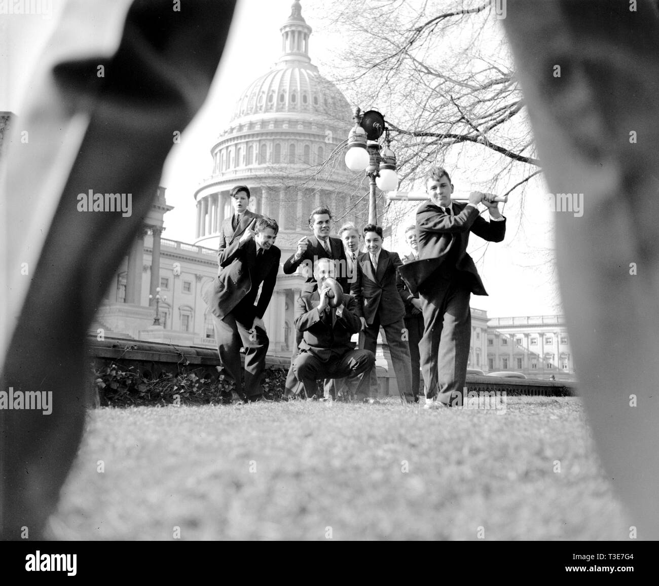 Baseball Spiel mit der Gruppe der Männer und Jungen (Seiten?) durch die Beine von Pitcher gesehen, mit U.S. Capitol im Hintergrund, Washington, D.C. Ca. 1939 Stockfoto