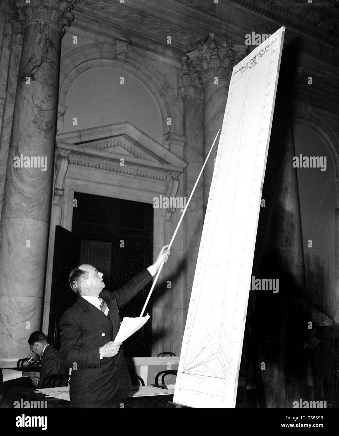 Mann in kongreßhörfähigkeit, der auf eine Linie auf einem sehr großen Diagramm kann. 1939 Stockfoto