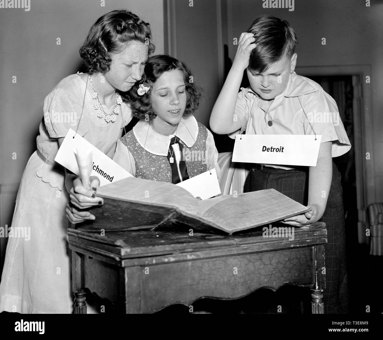 Die eilboten Spelling Bee Teilnehmer Foto inszeniert, Suchen nach Wörtern im Wörterbuch, 1940 Stockfoto